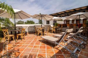 瓜达拉哈拉Puerta San Pedro的一个带桌椅和遮阳伞的庭院