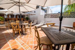 瓜达拉哈拉Puerta San Pedro的一个带桌椅和遮阳伞的户外庭院。