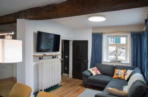 布兰肯海姆Zum-Goldenen-Schaf的客厅配有沙发和墙上的电视