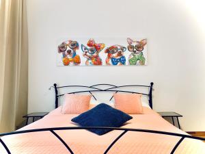 维也纳City-Maisonette的一间卧室配有一张床铺,墙上挂有四只狗画