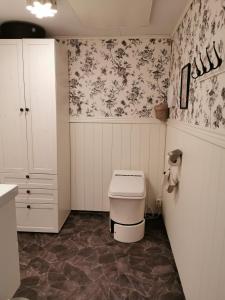 基律纳北极美食山林小屋的浴室设有卫生间和花卉壁纸。