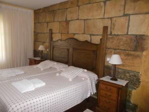 Santa GadeaHotel Rural El Rincón de Gadea的一间卧室设有一张床和石墙