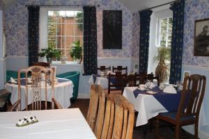 泰姆老红狮宾馆的一间配备有桌椅的用餐室和蓝色的墙壁
