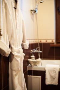 基希讷乌艺术质朴精品酒店的浴室设有挂在水槽旁的白色长袍