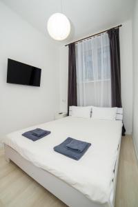 波尔塔瓦Atlas Hotel的卧室配有白色床和平面电视