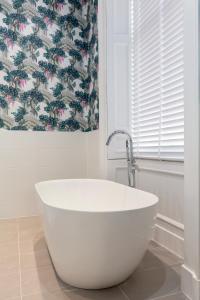 爱丁堡莱恩酒店的浴室设有白色浴缸,配有花卉淋浴帘