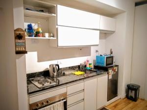 布宜诺斯艾利斯Cozy Apartment in Nuñez的小厨房配有白色橱柜和水槽