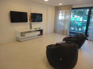 福塔莱萨Fortaleza VIP Experience的客厅配有2把椅子和平面电视