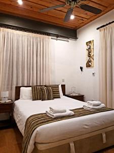 卡洛帕尼亚伊奥蒂斯阿彻蒂克伊米西尔洛酒店的一间卧室配有一张大床和毛巾