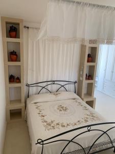 NocigliaAgriturismo Messer Gesualdo的一间卧室配有一张带白色窗帘的床