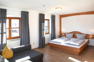 普夫龙滕Alps Hostel的一间卧室配有一张床和一张沙发