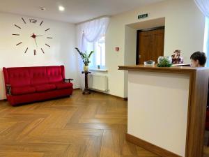 米尔哥罗德RioRo的一间设有红色沙发的房间和墙上的时钟