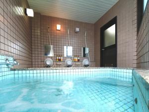 大町市纳库罗斯传统日式旅馆 的浴室设有大型蓝色海水游泳池