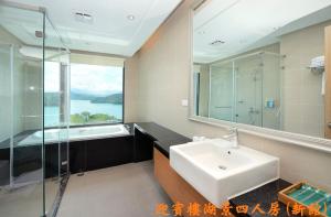 鱼池乡日月潭教师旅舍的浴室配有盥洗盆、镜子和浴缸