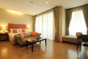 清莱清莱乐帕塔酒店 SHA Extra Plus的酒店客房配有床、沙发和桌子。