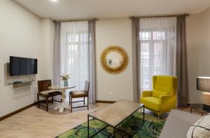 奥维多DE LA GUARDIA SUITE 1的客厅配有黄色椅子和桌子