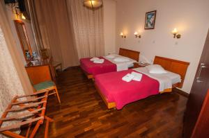 雅典塞西尔酒店的两张位于酒店客房的床铺,配有红色床单