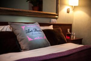 基希讷乌艺术质朴精品酒店的枕头坐在床上,带镜子