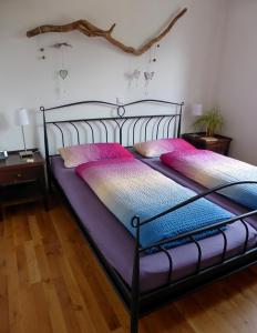 林登贝格Ferienwohnung VITA的一间卧室配有两张带粉色和紫色床单的床