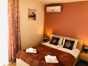 莫斯塔尔Hotel Malta的一间卧室配有两张带毛巾的床
