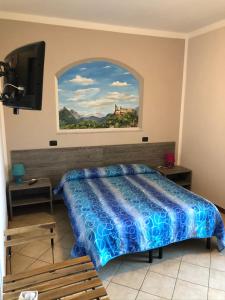 阿维利亚纳伊尔加托和拉沃尔普酒店的卧室配有一张床,墙上挂有绘画作品