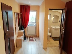 索利纳Apartament TARA的一间带红色窗帘和卫生间的浴室