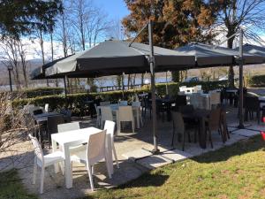 阿维利亚纳伊尔加托和拉沃尔普酒店的一组桌子和椅子,放在伞下