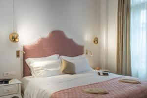 塞萨洛尼基Bahar Boutique Hotel的一间卧室配有一张带粉红色床头板的大床