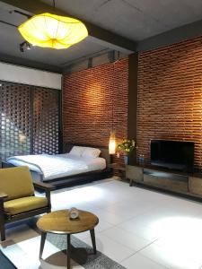 岘港Ngói house的一间卧室配有一张床,并在一间客房内配有电视。