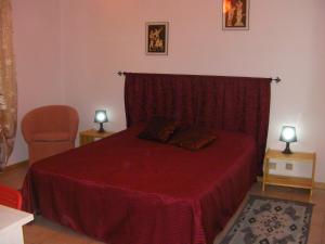 苏特里Etruria Life的一间卧室配有一张带红色毯子和椅子的床
