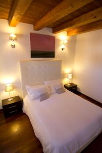 锡拉库扎拉维亚德拉古德卡酒店的一间卧室配有一张带两盏灯的大型白色床。