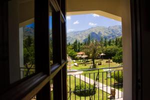 梅洛El Cortijo Apart - Hotel的享有公园和山脉景致的窗户。