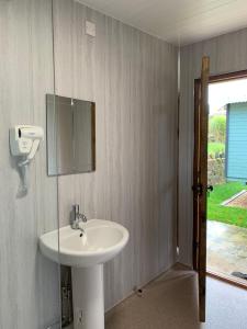 特伦特河畔斯托克Glamping at Holly Grove Farm的浴室设有水槽和墙上的镜子