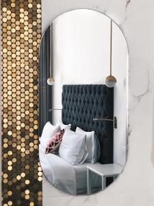 塞萨洛尼基Bahar Boutique Hotel的一张镜子,一张沙发和枕头
