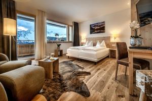 阿罗萨高尔夫球－&霍夫马朗运动酒店的一间卧室设有一张床和一间客厅。