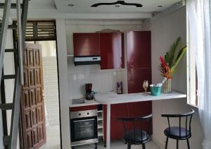 拉芒坦SaS NEMO的一间厨房,配有红色橱柜和两个酒吧凳子