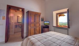 卡梅拉诺Il Girasole Country House的一间卧室配有一张床、梳妆台和电视。