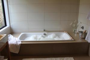 旺阿雷Te Kahu的浴室内设有带白色毛巾的浴缸