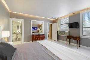 棕榈滩ORCHID SUITES - Historic Palm Beach Hotel Condominium的一间卧室配有一张床、一张书桌和一台电视
