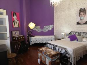 布宜诺斯艾利斯Andiamo Guest House的一间设有两张床和紫色墙壁的客房