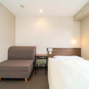 上越市Super Hotel Joetsu Myoko-Eki Nishiguchi的酒店客房,配有两张床和椅子
