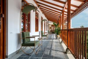 蓬蒂切里Grand Hotel D'Europe的房屋内带绿色椅子的门廊