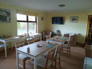 TurriffDeveron Lodge Guest House的一间带2张桌子和椅子的用餐室