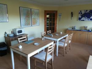 TurriffDeveron Lodge Guest House的一间带2张桌子和微波炉的用餐室