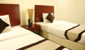 塞拉莱Rimal Suites Apartments的酒店客房设有两张床和一张桌子。