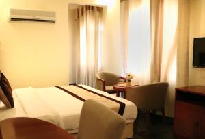 塞拉莱Rimal Suites Apartments的酒店客房带一张床、一张桌子和椅子