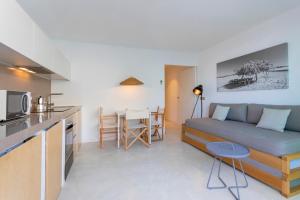 埃斯普霍斯Apartamentos Roca Plana的厨房以及带沙发和桌子的客厅。