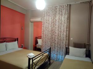 雅典萨皮恩酒店的一间卧室设有两张床和一个带窗帘的窗户。