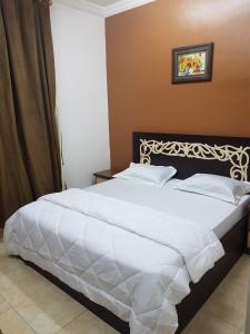 塞拉莱贝特阿尔穆鲁公寓式酒店的一间卧室配有一张带白色床单的大床