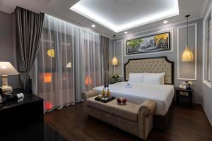 河内Babylon Premium Hotel & Spa的卧室配有一张白色的大床和一张沙发。
